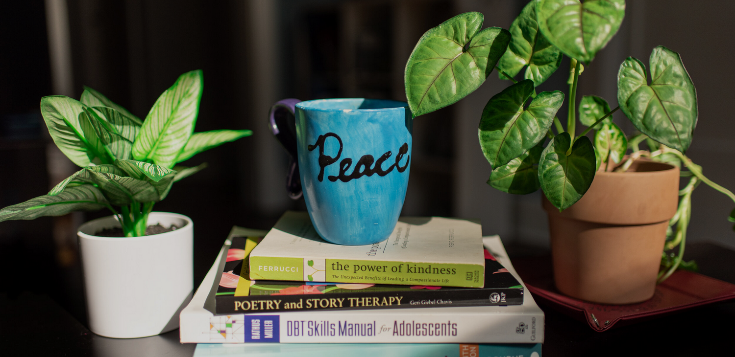 Gallery Photo of Here is a glimpse of my soothing tea mug and some essential books I use: poetry therapy and DBT!