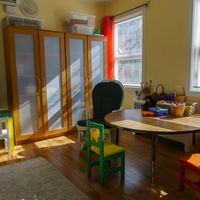 Gallery Photo of art supplies, toys, doll house and tables for the comfort of younger people to explore their imagination and inner worlds