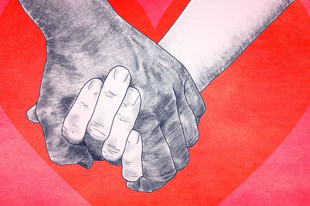 Red and pink background with a two individuals holding hands.