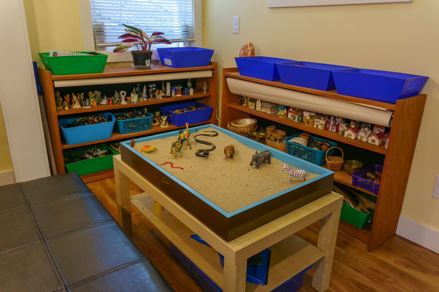 Gallery Photo of a full size sand tray with many figurines, tools and items to facilitate imaginary landscapes and inner worlds