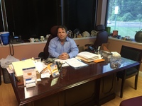 Gallery Photo of Dr. Baruch at his desk. About as neat as it gets. If he owns a tie we've never seen it. Waste basket is emptied 1X/year whether it needs it or not.