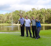 Gallery Photo of Four of our staff members out on our golf green posing in front of the lake