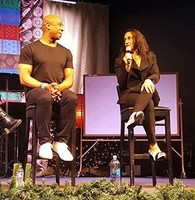 Gallery Photo of Dr. Cali Estes speaking on stage with Broncos Player #82 Vance Johnson at the Navigating Addiction Summit.