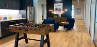 Gallery Photo of Game room, lounge, and kitchen inside Embark at Atlanta North. 