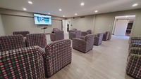 Gallery Photo of Spacious well-lit training room with comfortable chairs and 85" screen.