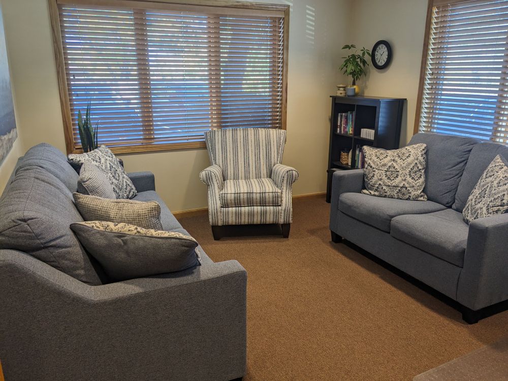 View of therapy room with comfortable couches, and natural light. 